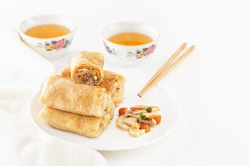 Traditional Chinese tortillas filled - bings in a plate with mushrooms on a white background, cups of tea. Copy space