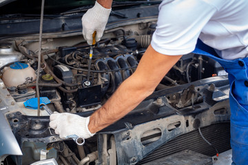mechanic men with wrench repairing car engine at