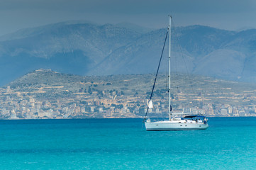 Corfu, Panorama to the mountain peaks in Albania, sailing yacht on the sea.