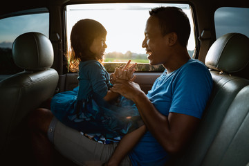 asian daughter with father in the car playing