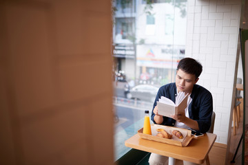 Man reading a book in a coffee shop