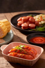 Grilled sausages with sauce ketchup on a wooden table