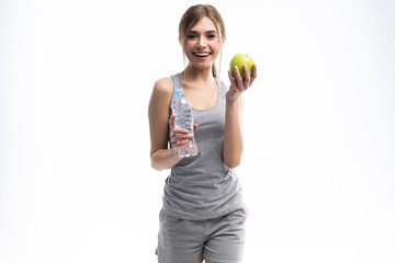 Portrait of young attractive woman with green apple and bottle. Dieting concept. Isolated on white