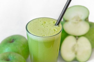 Fresh green apple drink surrounded by green apples