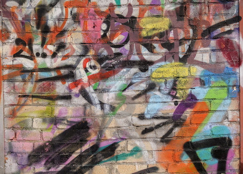 Street art. Abstract background. Chaotically painted brick walls with multi-colored paint