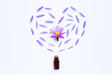 Essential oil with Purple lotus flower on white.