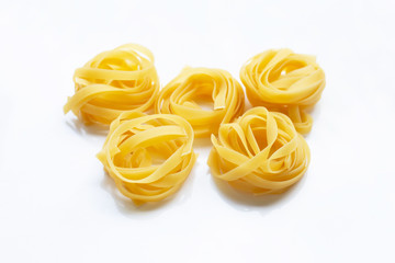 Italian pasta tagliatelle nest on white