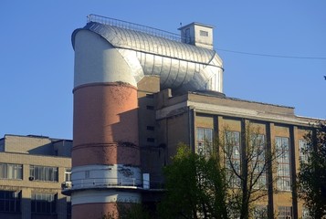 Vertical aerodynamic tube against the blue sky. Beautiful industrial landscape.