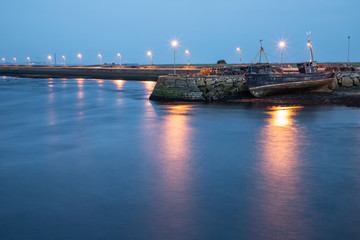 Fototapeta na wymiar Abandoned boat in the pier around Corrib river in Galway