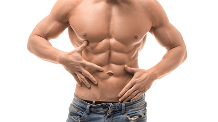 Muscular male torso isolated on white. Shirtless man in blue jaens touching his abs