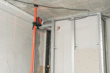 Laser measurement during renovation. Construction tools and equipment. Red laser light lines for level measure.