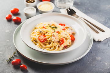 Delicious salmon linguine pasta dish with herbs and grilled salmon filet.