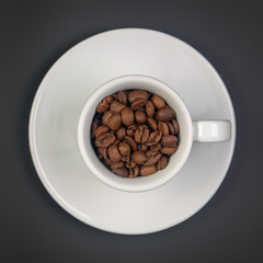 coffee beans in white Cup with saucer on black background, top view