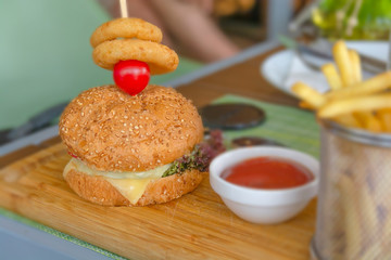 Obraz na płótnie Canvas Fresh tasty burger, fries and tomato on wooden table