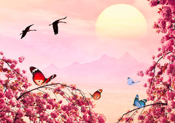 Free birds fly on pink magic sunrise over sea. Migrating cranes. Misty mountain landscape in blurry background. Spring tree branches blooming. Butterflies flit over the flowers. Inspiration dreams 