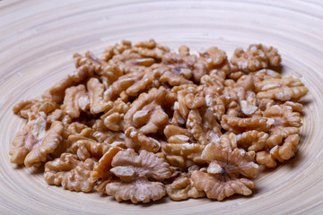 Walnuts on the wooden plate on the table