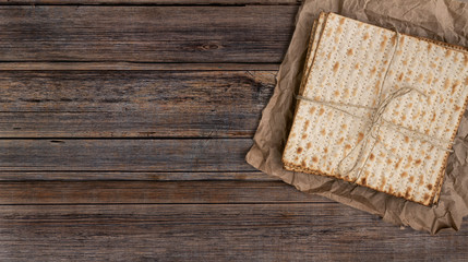 Fototapeta na wymiar Pack of matzah or matza on a vintage wood background with copy space or text space. Top view or above view composition.