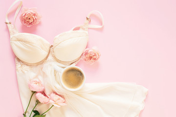 Composition of white cup with black coffee and flowers on a light pink background. Morning concept. Flat Lay. Top View