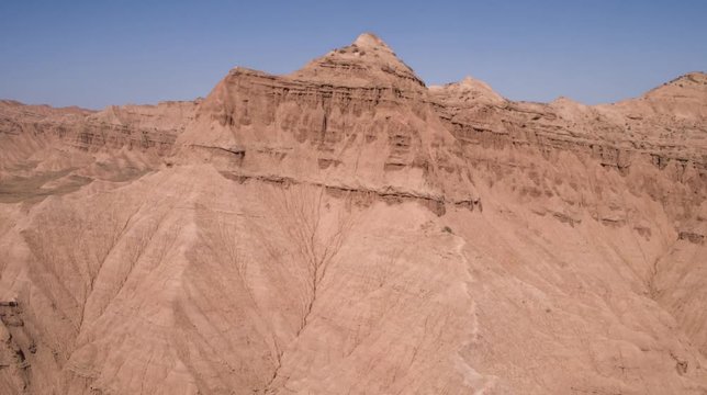 Aerial flight in the desert over sharp sandy cliffs, mountains. Panoramic view. Iran.