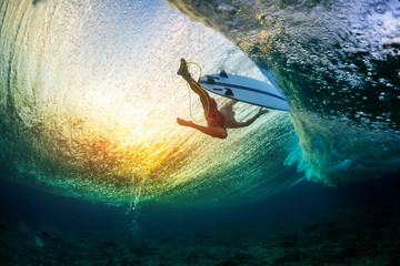 Underwater view of the surfer floating on the water surface after passing the big wave