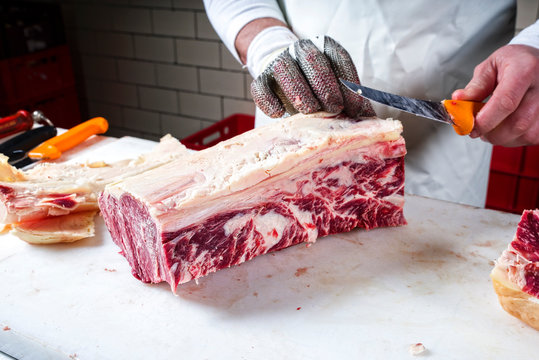 Rohes dry aged Wagyu Roastbeef Steak beim zerlegen durch einen Metzger in der Metzgerei als closeup