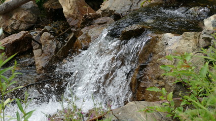 Fototapeta na wymiar Waterfall among stones and rocks