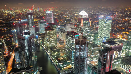 Fototapeta na wymiar Aerial drone night shot from iconic Canary Wharf illuminated skyscrapers business and financial area, Docklands, Isle of Dogs, London, United Kingdom