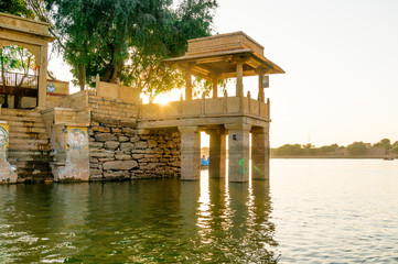 Central island park with sandstone buildings and trees growing at gadi sagar jaisalmer