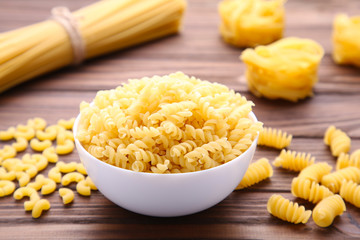 Delicious mixed pasta on brown background with copy space