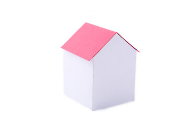 A paper house with red roof on a white background.