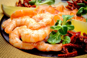 cooked shrimp on plate with seafood and dried tomatoes
