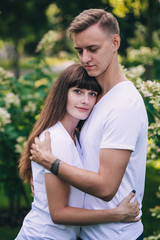 Fototapeta premium Meeting lovers in the park. The guy and the girl retired in flowers.
