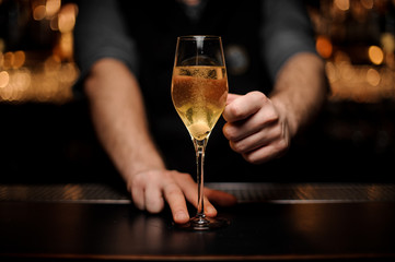 Male bartender serving cocktail with a sugar cube in the glass