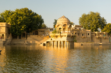 Obraz premium Sandstone chattri domes with steps on gadi sagar lake in jaisalmer at dusk