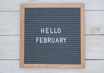 English text Hello February on a letter Board in white letters on a gray background