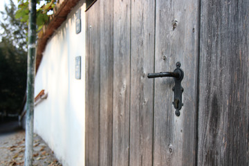 The Modern wooden door with metal door handle over the white wall. -Image