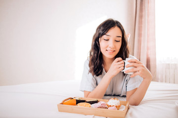 Obraz na płótnie Canvas Young woman eating healthy breakfast in bed