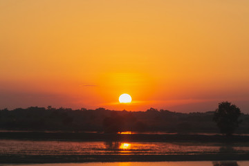 Sunset in the lake. beautiful sunset behind the clouds above the over lake landscape background. dramatic sky with cloud at sunset