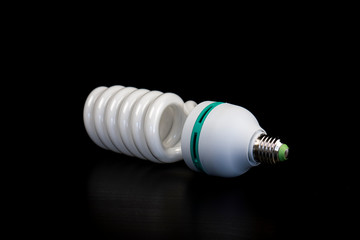 Energy saving light bulb isolated on black table