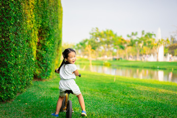 Little girl riding balance bike in the park