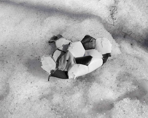 torn ball for playing soccer lying on the snow