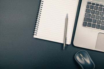 Top view of office desk with notebook pen and laptop