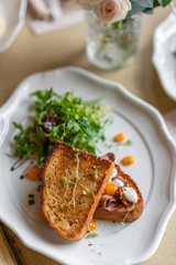 French toast brioche, Sandwich with pastrami and sun-dried tomatoes. Light morning Breakfast, fresh warm pastries on table in restaurant