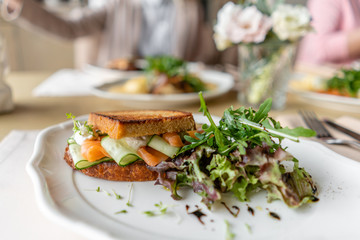 French toast brioche, Sandwich with salmon and cucumber. Light morning Breakfast, fresh warm pastries on table in restaurant