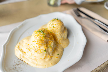Egg Benedict on warm toast brioche. Two eggs delicious hollandaise sauce. Light morning Breakfast on table in restaurant.