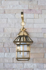 Outdoor wall golden lantern on the tile wall.