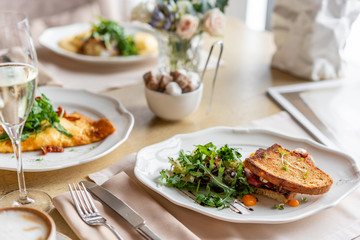 French toast brioche, Sandwich with pastrami and sun-dried tomatoes. Light morning Breakfast, fresh warm pastries on table in restaurant