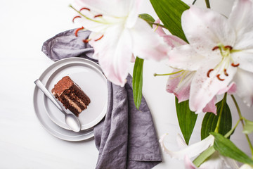 Piece of chocolate cake in gray plate on a white background.