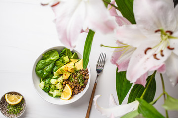 Vegan flat lay of green salad with spinach, lentils, avocado and cucumber.