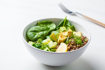 Green salad with spinach, lentils, avocado and cucumber.